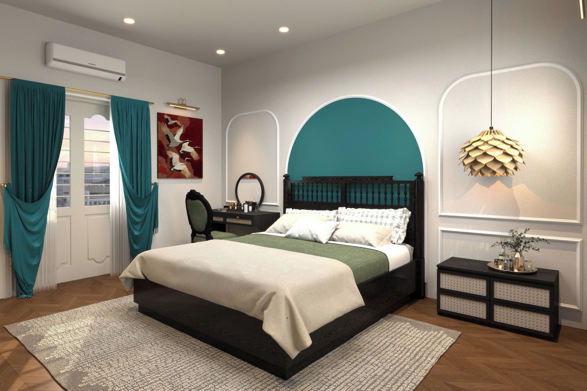 A bedroom with a bed, a desk, and a chair.