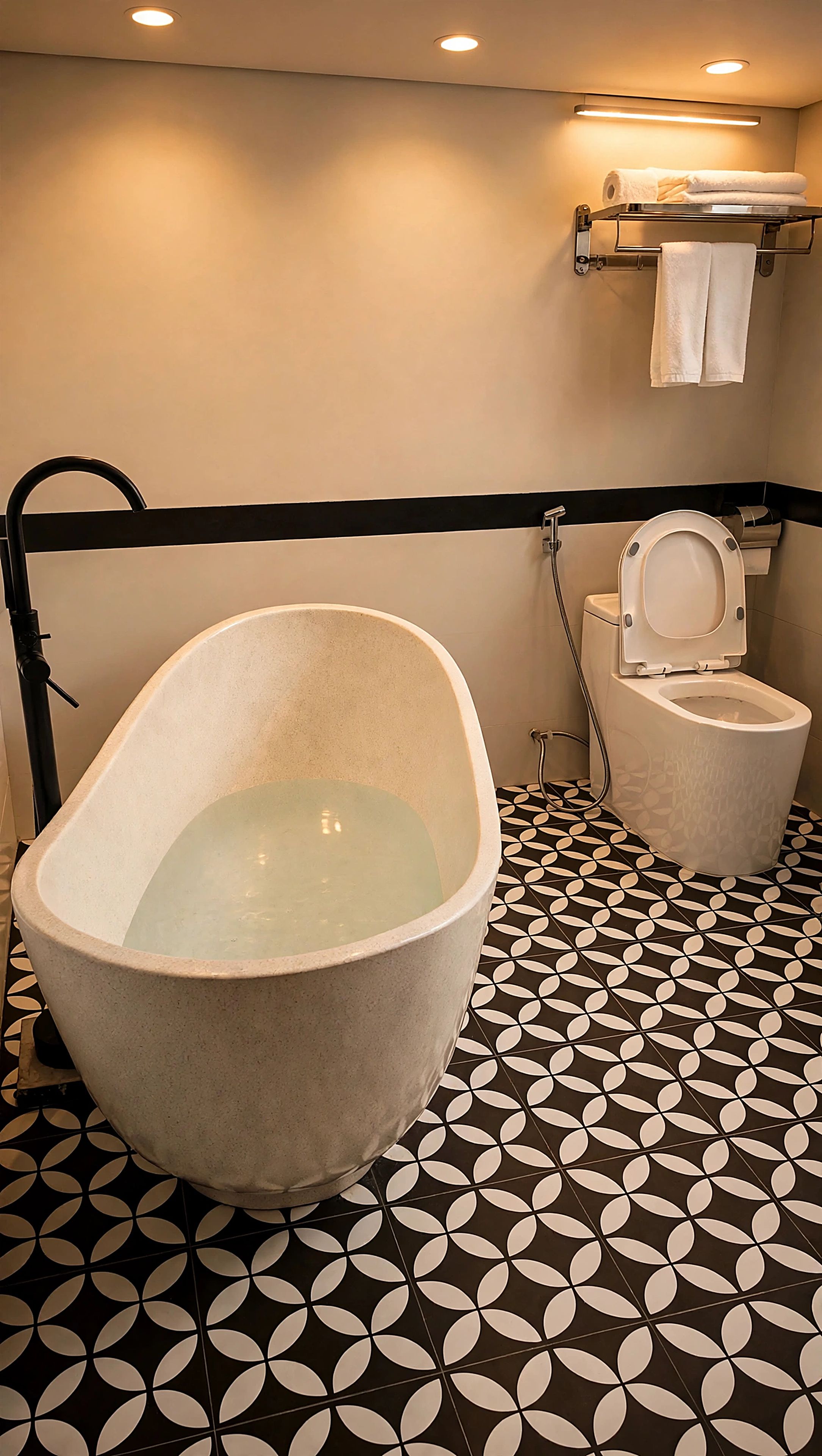 Un baño con una bañera independiente, un inodoro y un perchero para toallas.