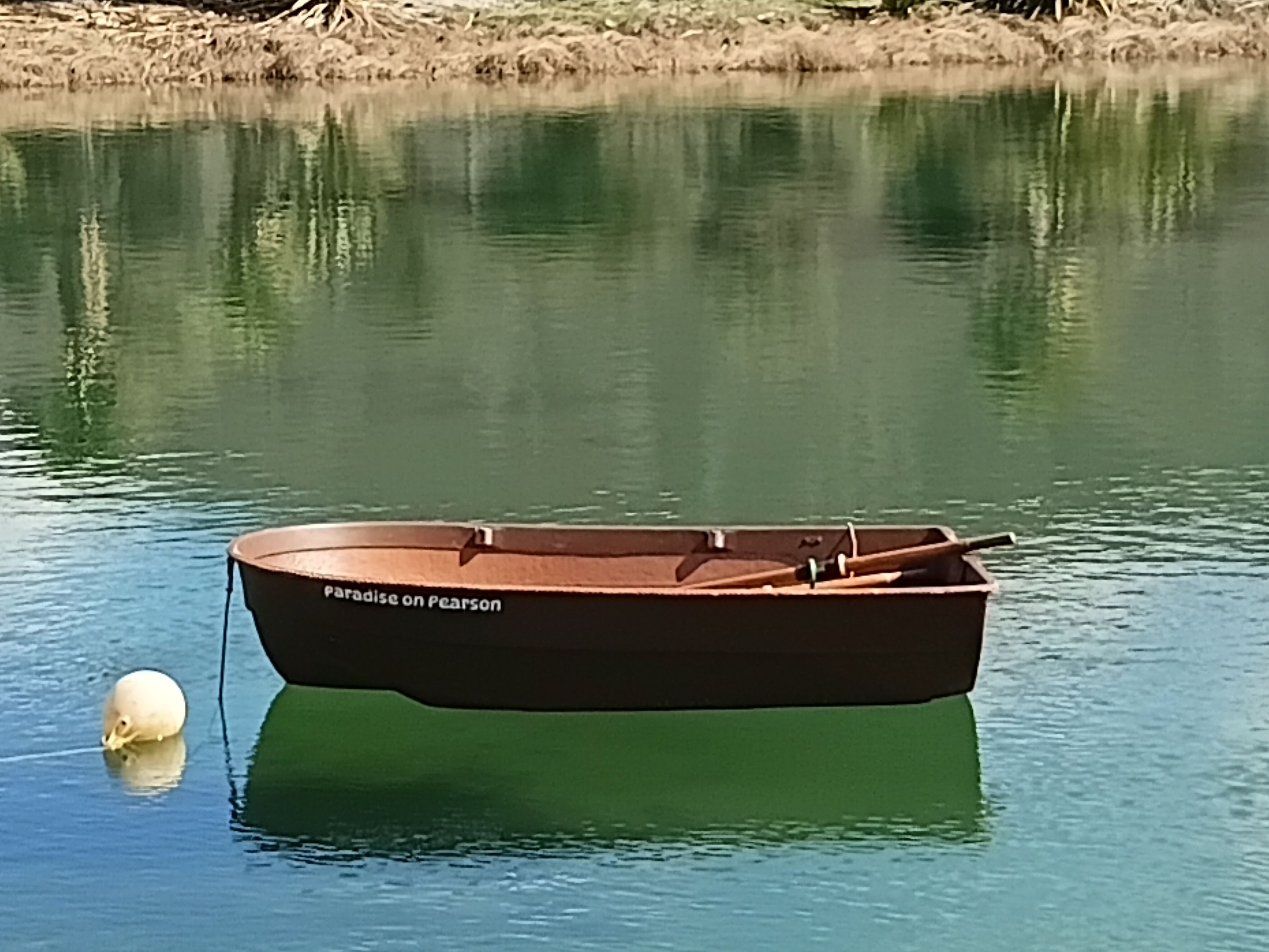 Un petit bateau baptisé « Paradis sur Pearson » était amarré sur une étendue d’eau calme.
