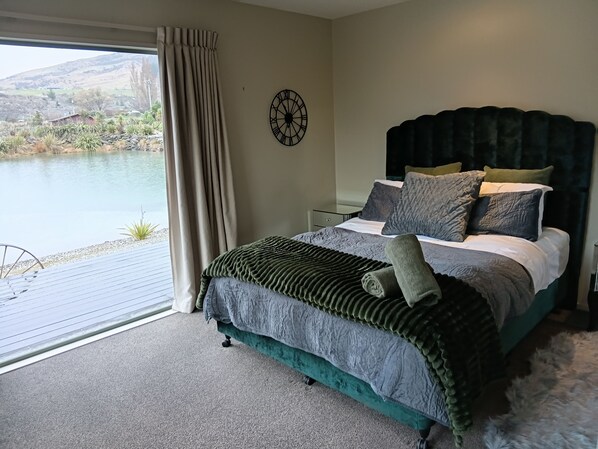 Un dormitorio con una cama, un reloj y vistas a un lago.