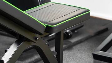 A piece of exercise equipment with a padded seat and footrest, a metal frame, and a base with wheels.