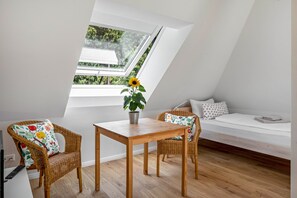 A room with a skylight, a wooden table, wicker chairs, a sofa, and a potted plant. - Apartment 'Fuchs und Has Feldberg - Neu Eröffnung Juli 2026 - App 7/ Gemeinschaftsgarten/ Sauna/ Aussicht' (Feldberg)
