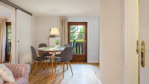 Ein Essbereich mit Tisch, Stühlen, einer Lampe und Blick durch ein Fenster.
