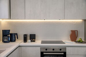 Eine moderne Küche mit Backofen, Kaffeemaschine und Wasserkocher.