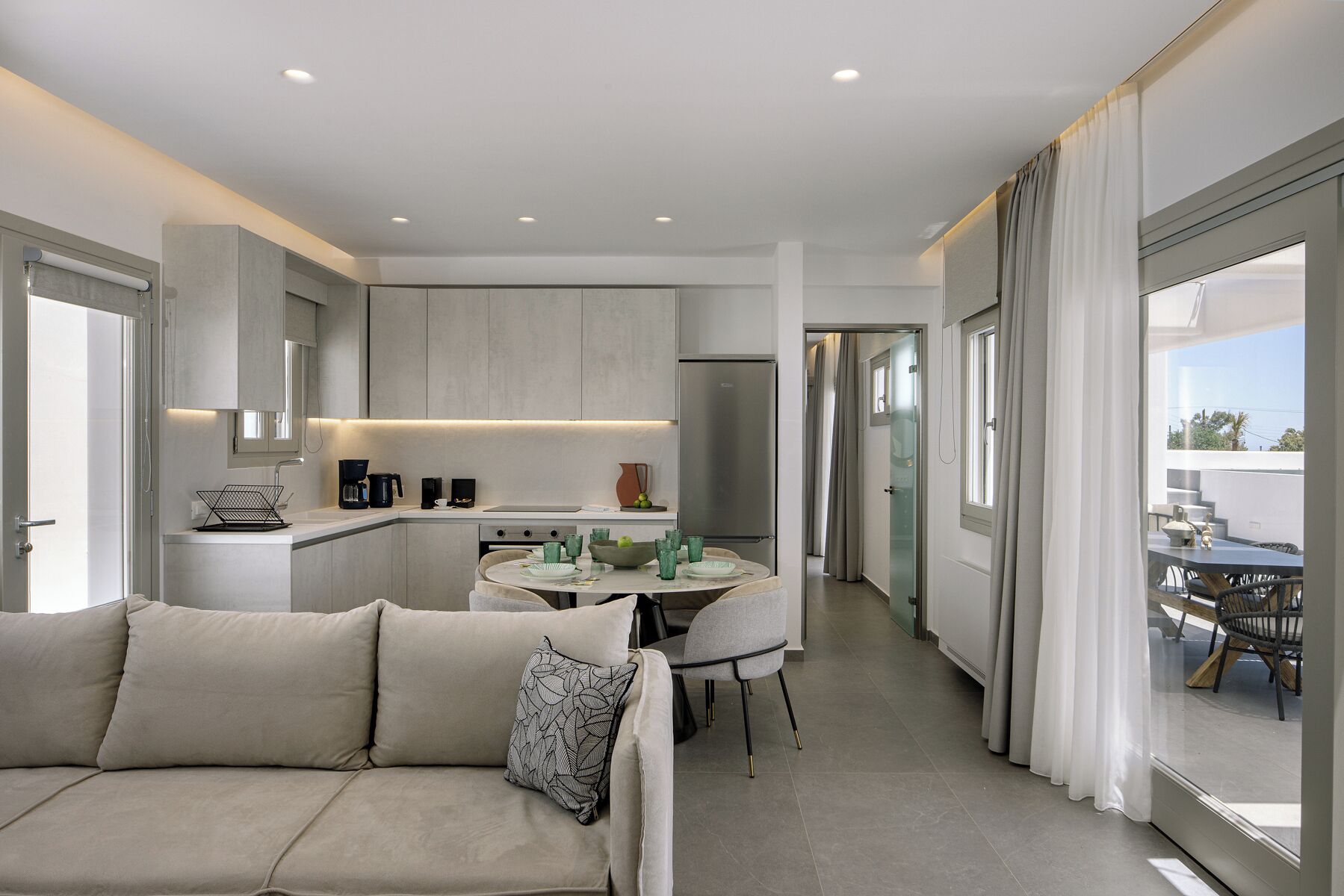 Una cocina moderna con comedor, sofá y vistas al exterior.