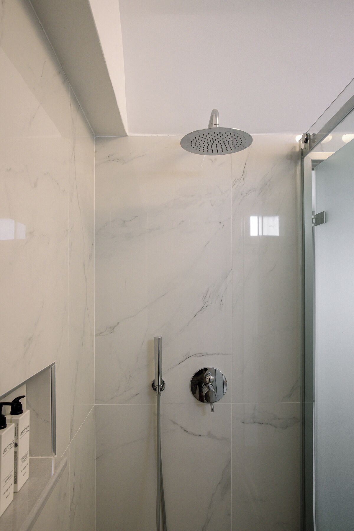 Eine moderne Dusche mit Regendusche, Handbrause und Wandarmatur.