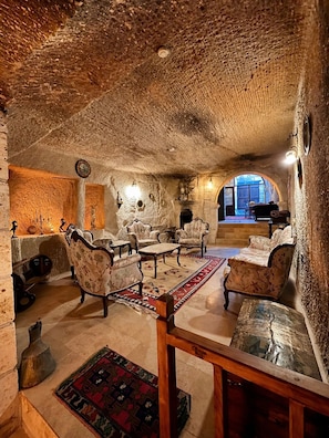 Ein gemütliches Interieur mit Steinwänden, Kamin und traditionellen Möbeln.