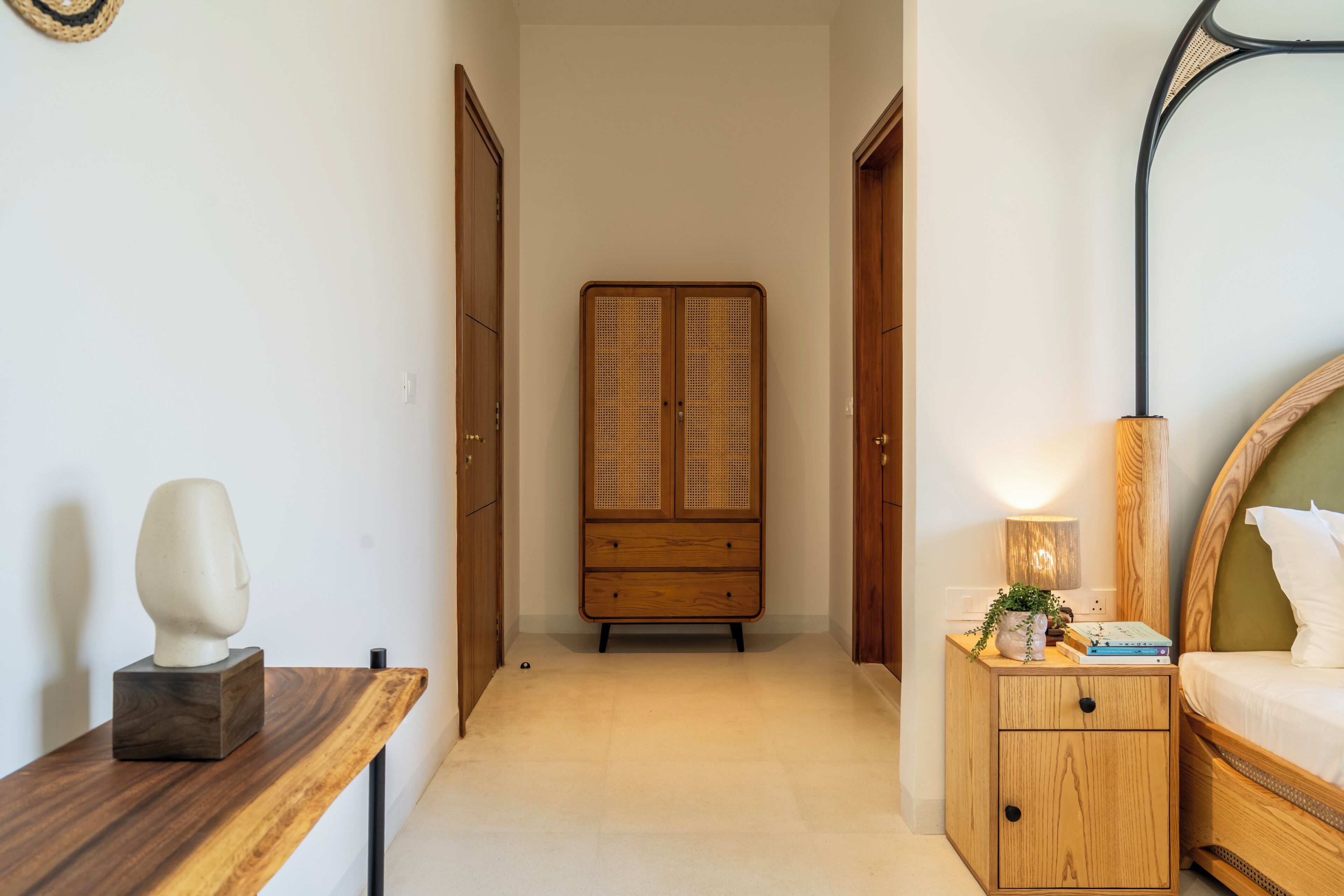 A bedroom with a bed, bedside table, nightstand, and a wardrobe.
