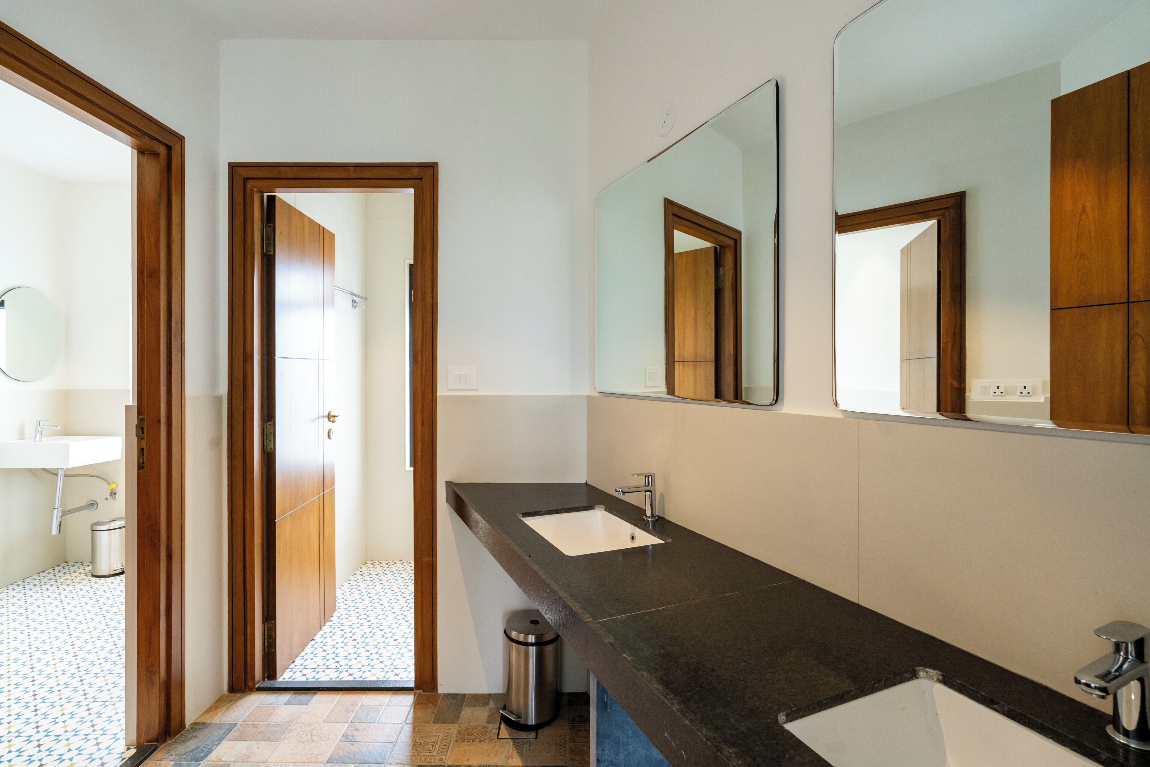 A bathroom with a double sink, a mirror, and a shower area.