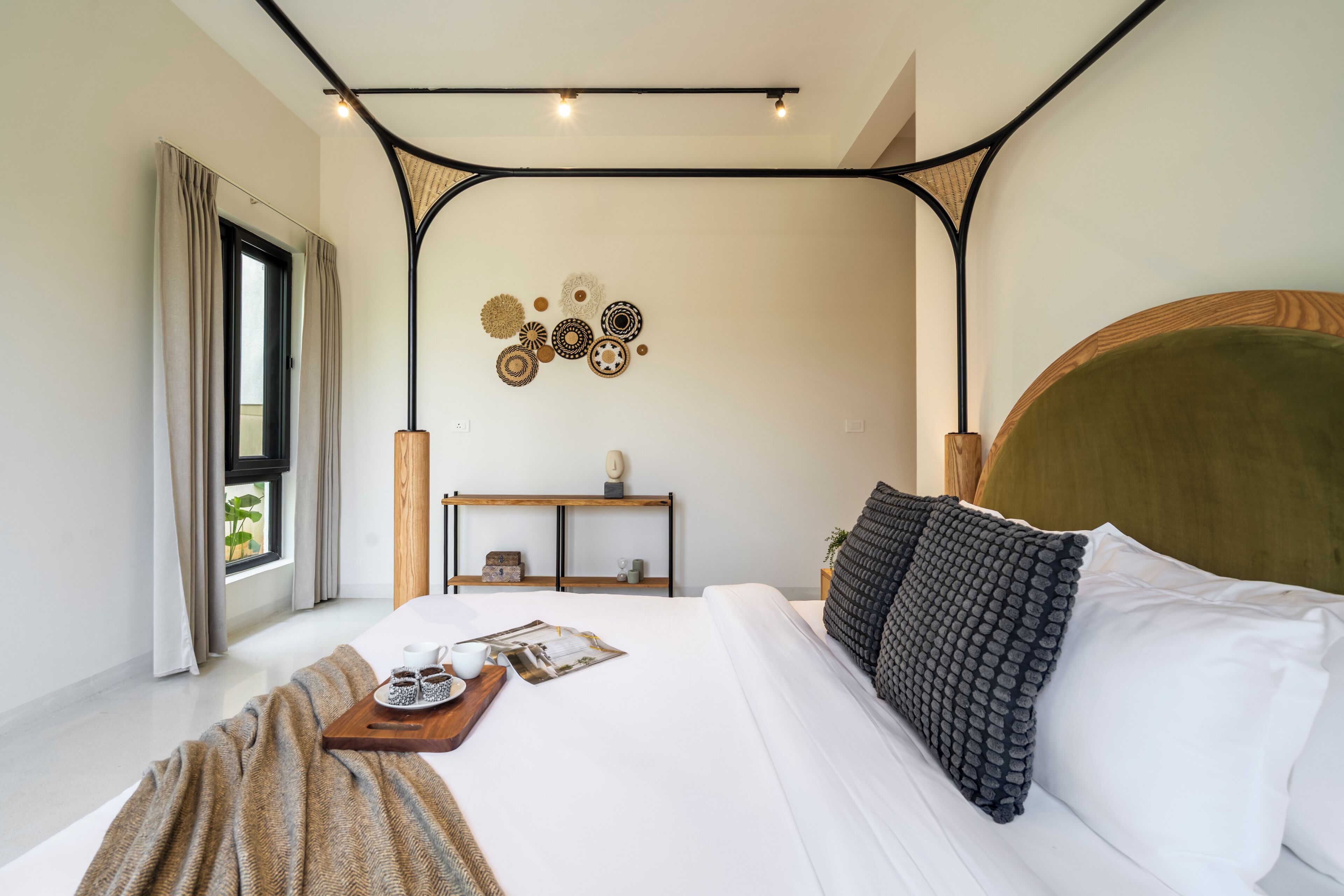 Un dormitorio moderno con una cama grande, mesitas de noche, un estante en la pared y una ventana con cortinas.