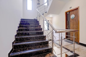 A staircase with a metal handrail leading to a wooden door with a 'Welcome' sign. - FabHotel Casa Mandrem (Mandrem)