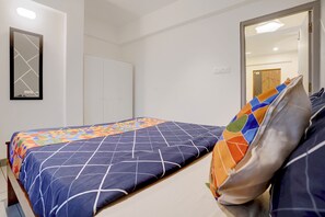 Un dormitorio con cama, armario y espejo.