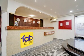 A hotel reception area with a reception desk, a clock, and a sign for 'Tab Hotels'. - FabHotel Mv Luxury Rooms (Hyderabad)