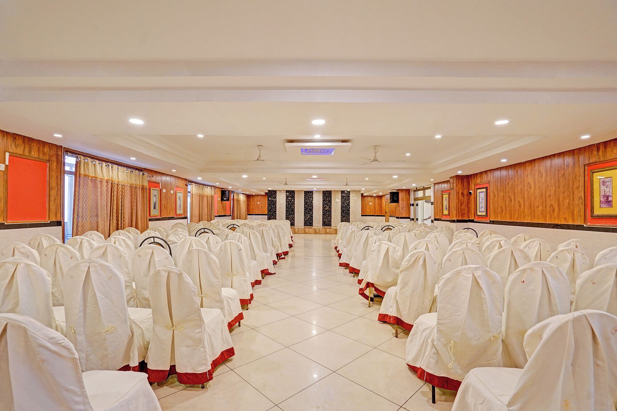 Uma sala de conferências com fileiras de cadeiras, um púlpito e um palco.