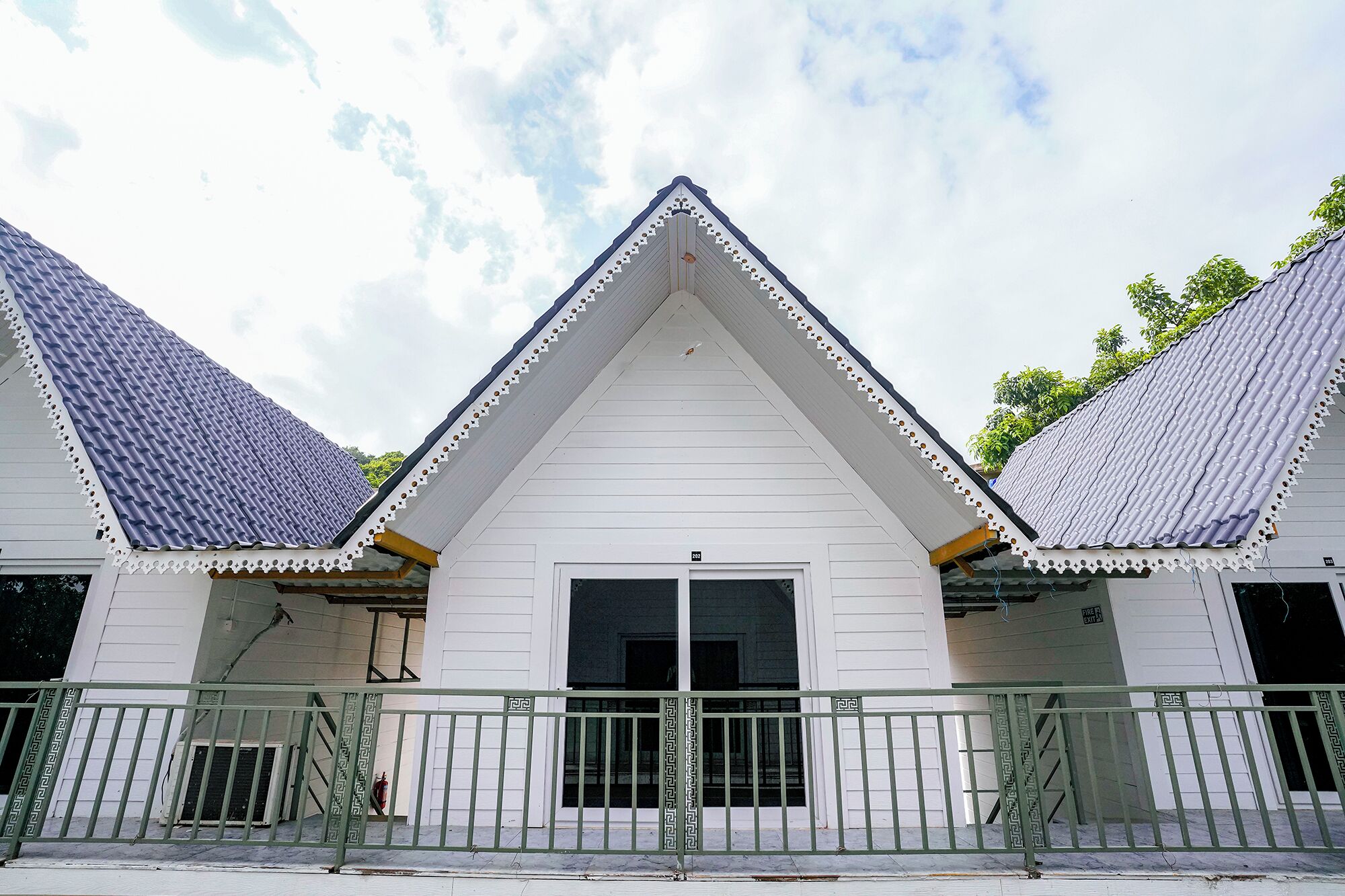 A building with a symmetrical facade, a central entrance, and a gated driveway.