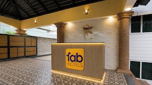 A reception area with a 'fab hotels' sign, a tiled floor, and a brick wall. - FabHotel Hill View Cottages (Arpora)