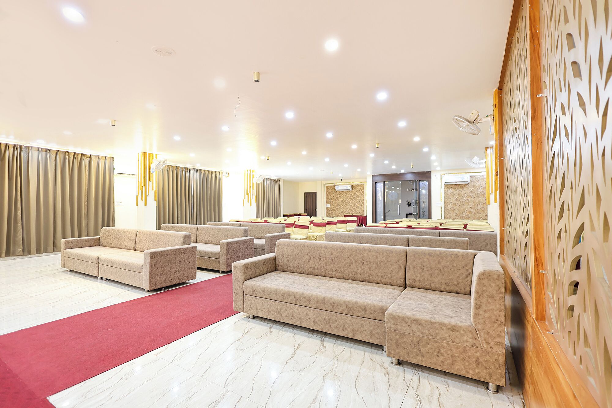 Amplia sala con varias zonas de estar, incluyendo sofás y sillones, dispuestas para eventos.