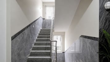 Una escalera con barandilla que conduce a un rellano con ventanal.