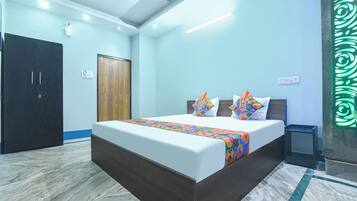 A bedroom with a bed, a wardrobe, a ceiling fan, and a decorative wall panel.