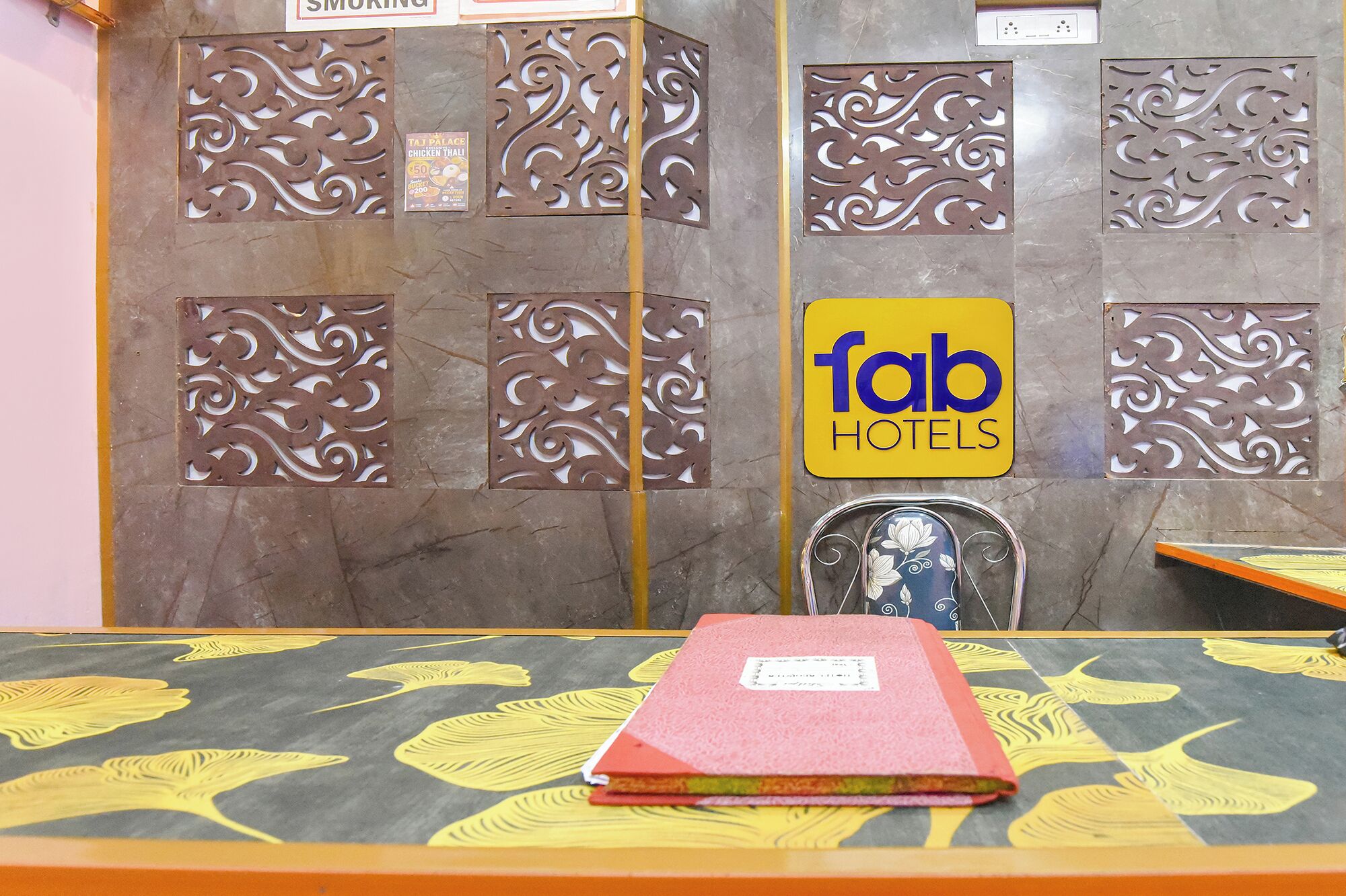 A hotel reception area with a sign for 'fab hotels' and decorative metal panels.