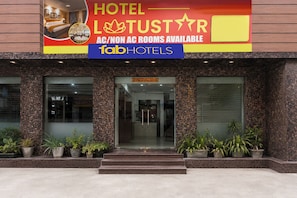 A hotel entrance with a signboard advertising AC/non-AC rooms and the name 'Tab Hotels'.