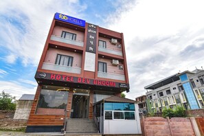 Un hotel con un letrero que indica 'HOTEL DEV BHOOMI' y 'HABITACIONES DISPONIBLES'.