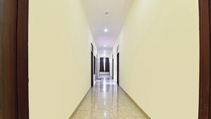 Un pasillo largo y estrecho con piso de baldosas brillantes y paredes de colores claros.