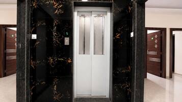 An elevator with a marble wall and a digital display showing the number 5.