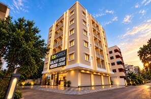 A multi-story hotel building with a sign for 'fabHOTELS Galaxy Stay Lodge'.