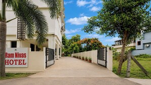 A gated entrance to Ram Nivas Hotel with a clear sky and greenery. - Fabhotel Ramnivas (Visakhapatnam)