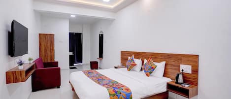 A modern hotel room with a large bed, a flat-screen TV, a wooden headboard, and a ceiling fan.