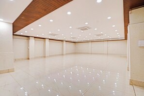 Um quarto amplo e vazio, com piso lustroso e iluminação embutida no teto.
