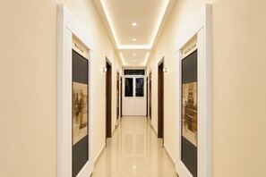 A hallway with doors labeled 'Photo Temple' and 'Golden Hour Escape,' leading to a room with a view. - FabHotel Gn International (Hyderabad)