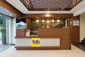 A reception desk with a clock, a 'No Smoking Area' sign, and a 'GATI' sign.