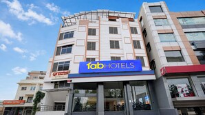 Un edificio de varios pisos con un llamativo letrero de 'fabHOTELS'.