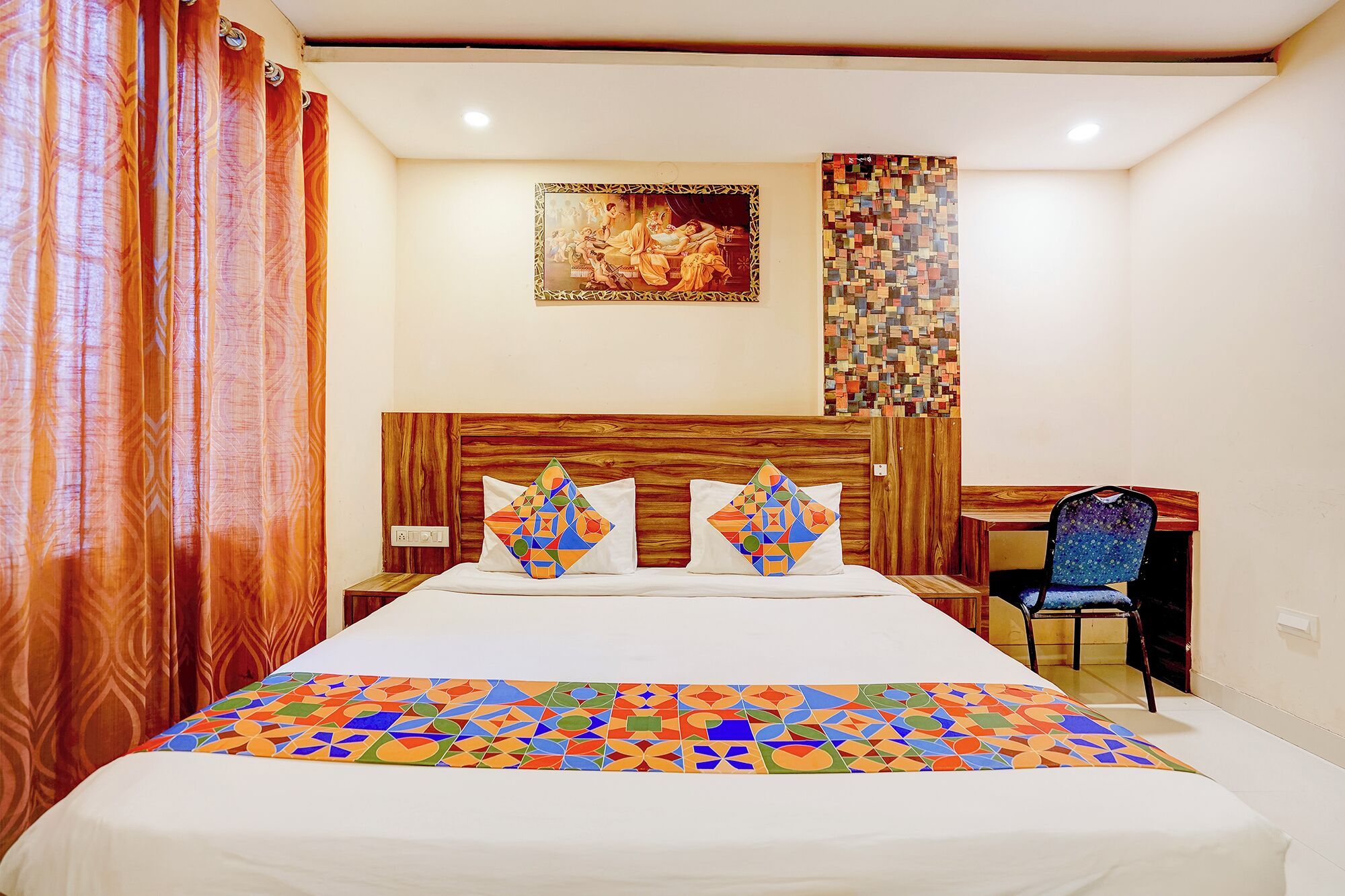 A hotel room with a bed, a desk, and a chair.