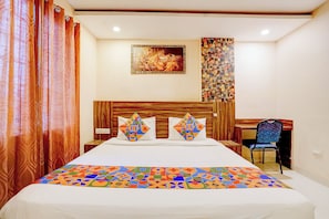 A hotel room with a bed, a desk, and a chair. - FabHotel Vaishnavi Inn (Hyderabad)