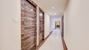 A hallway with a wooden door on the left and a white door on the right.