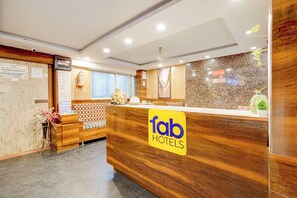 Un comptoir d'accueil d'hôtel avec un revêtement en bois et une enseigne indiquant « tab hotels ».