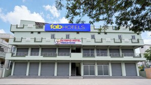 En byggnad med en skylt för Fab Hotels och en annan för Olympio Hotel Premium Rooms.