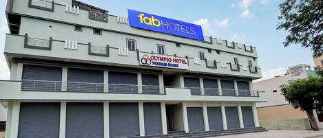 Un hotel con un letrero llamativo de 'Tab Hotels' y un cartel que anuncia 'Olympio Hotel Premium Rooms'.