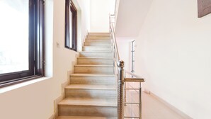 A staircase with metal railings and a handrail, leading to a landing with a door.