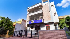 A multi-story building with a prominent 'Tab Hotels' sign, a gated entrance, and a visible 'Kartik Hotel' sign.