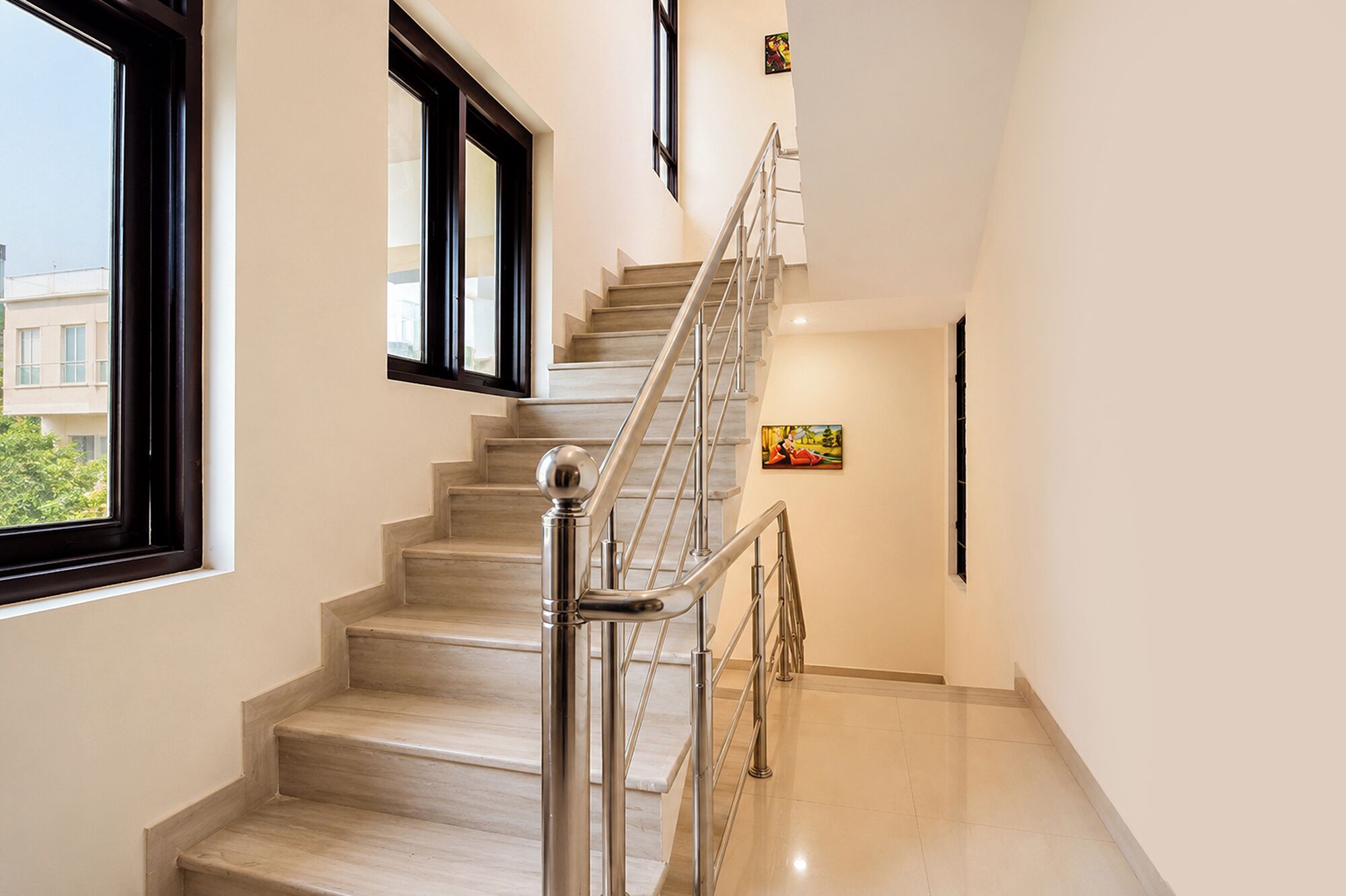 Una escalera moderna con barandilla de metal que conduce a un piso superior.
