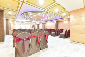 A conference room with rows of chairs, a marble floor, and a decorative ceiling. - Fabhotel Pacific View (Jaipur)