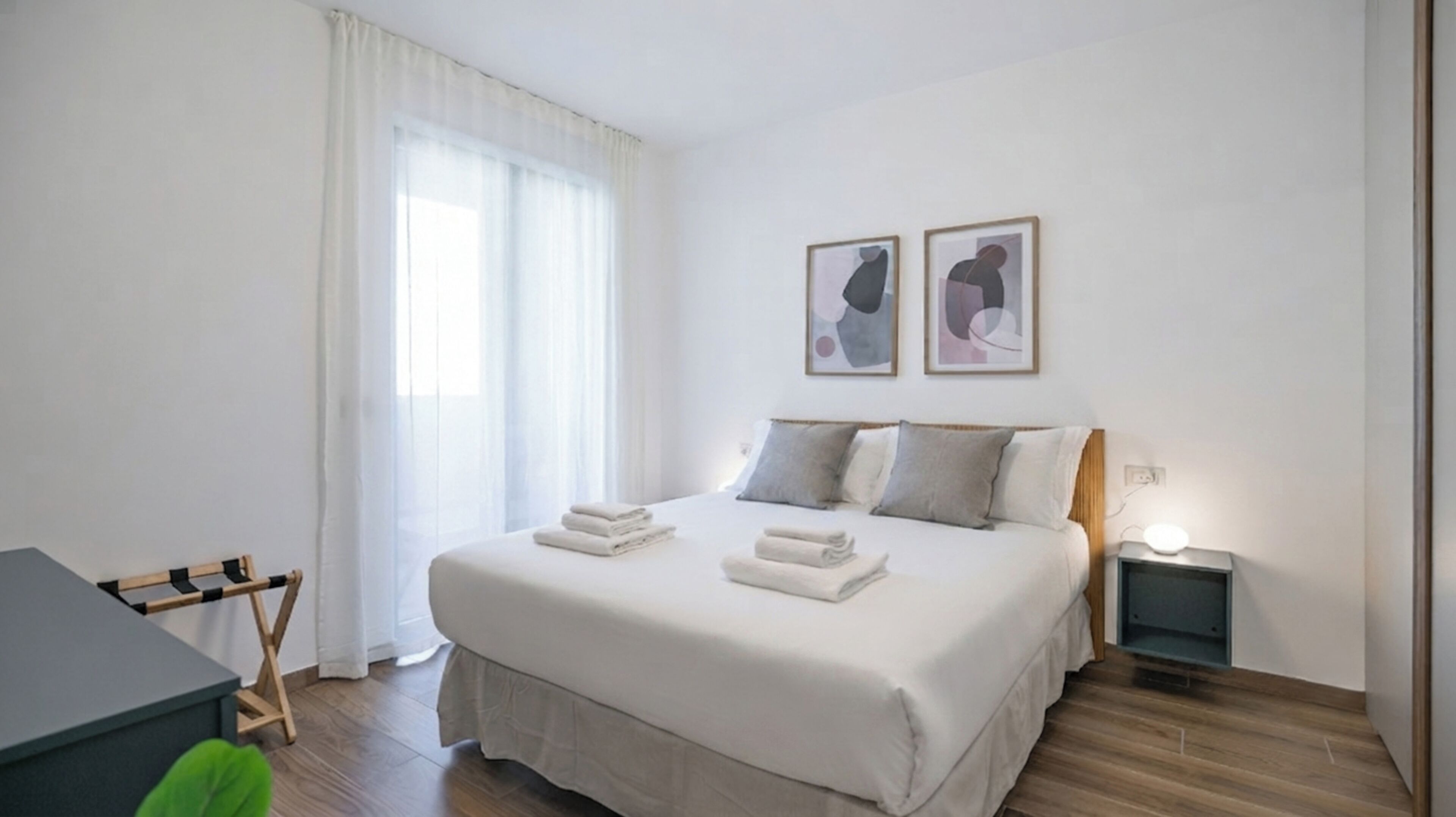Una camera d'albergo con un letto, comodini, una scrivania e una sedia.