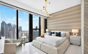 Une chambre d’hôtel moderne avec un grand lit, deux tables de chevet, une chaise et une vue sur les toits de la ville.