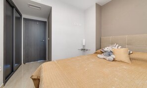 A bedroom with a bed, a nightstand, a lamp, a teddy bear, and a wardrobe. - Apartment Santa Ana Villamartin (Orihuela Costa)