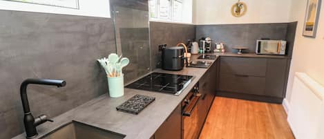 A modern kitchen with a built-in stove, a coffee maker, and a microwave.