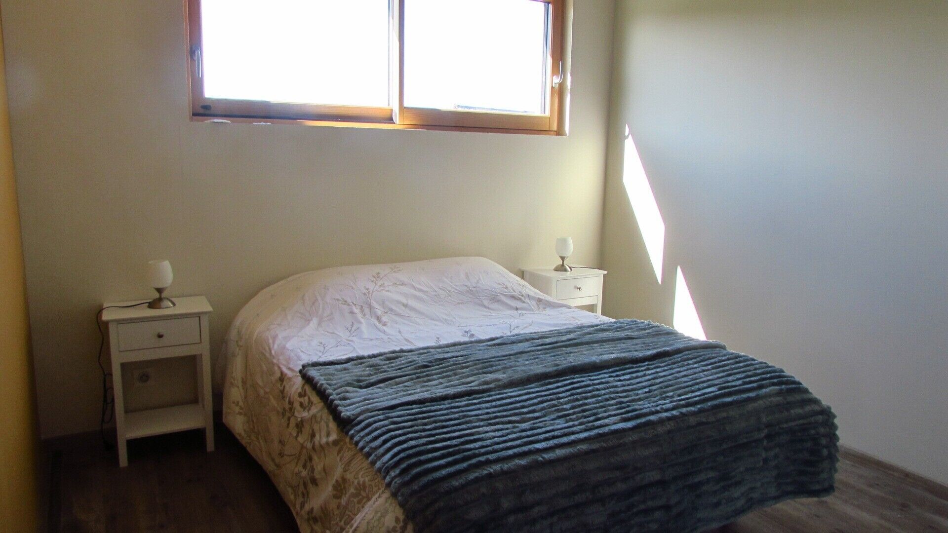 Una camera da letto con un letto, un comodino e una finestra.